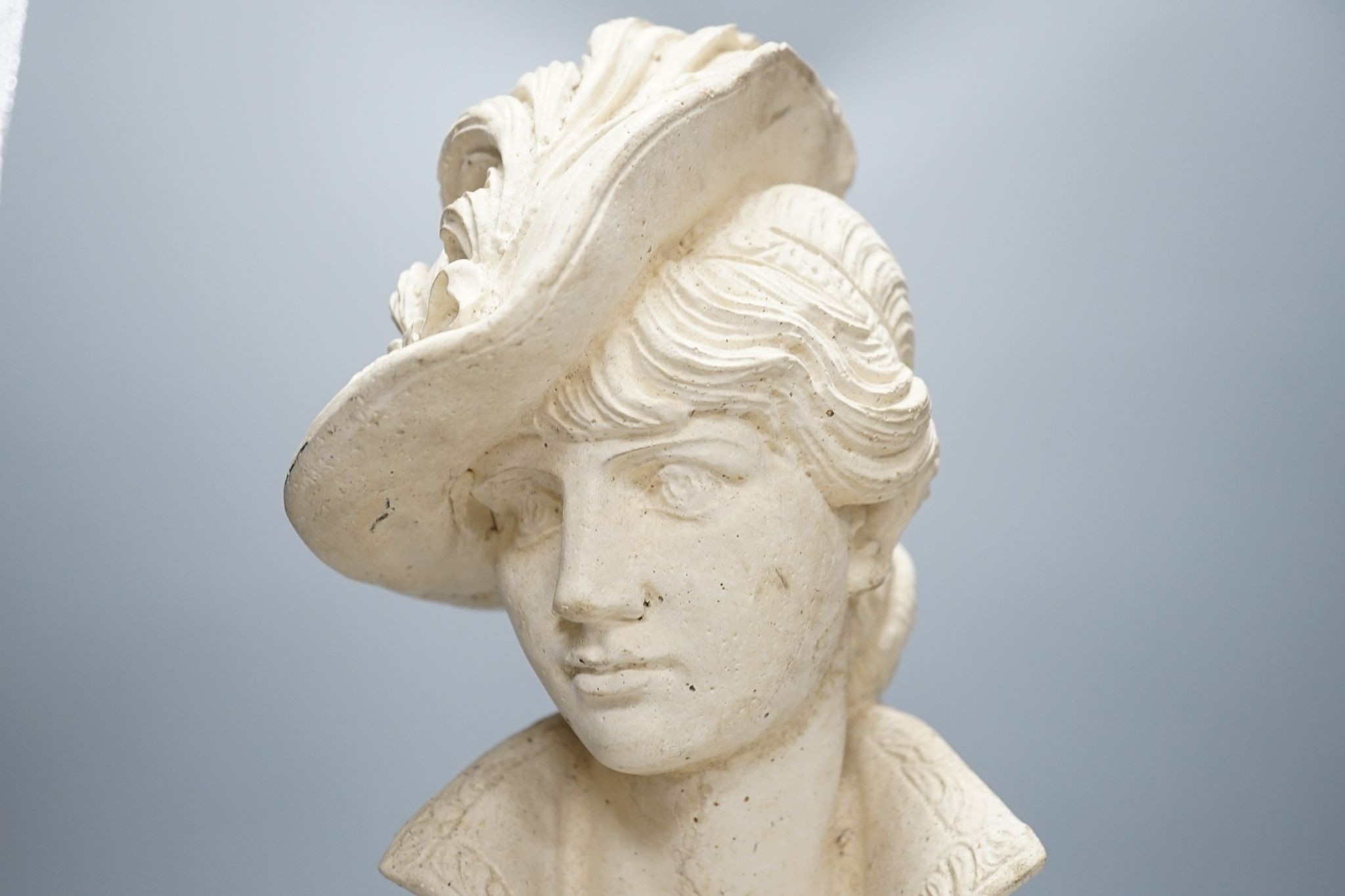 A composition bust of a 19th century lady in feather hat, 47 cms high.
